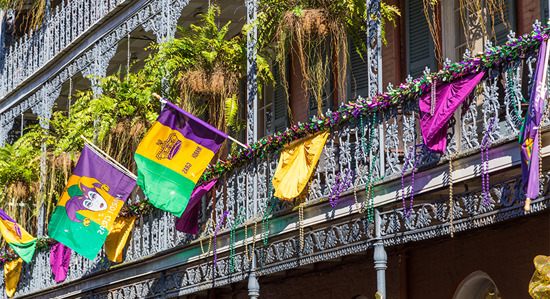 Downtown New Orleans with hanging plants and Mardi Gras decorations.